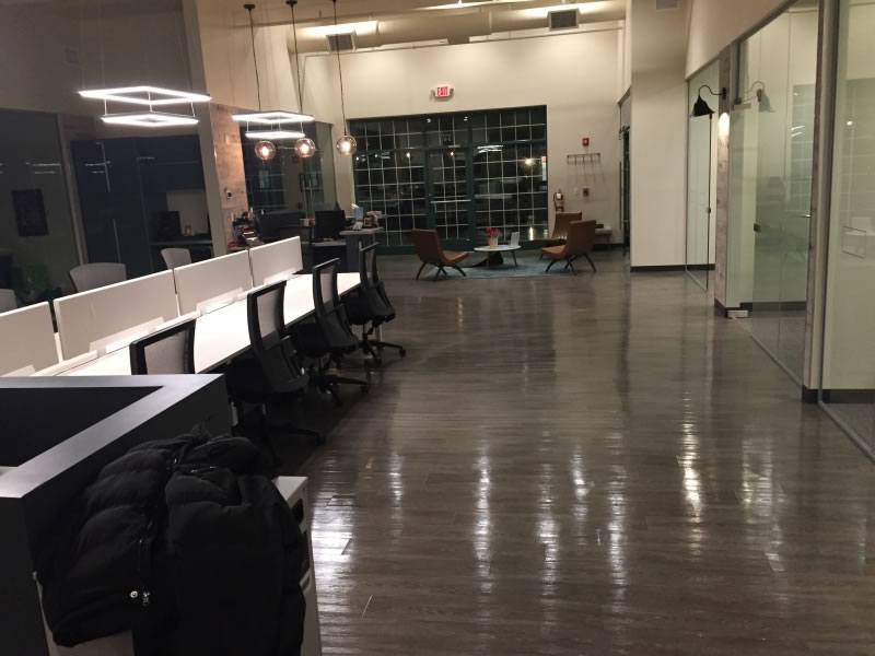 Reflective floor alongside desks and glass partitions in an open office.