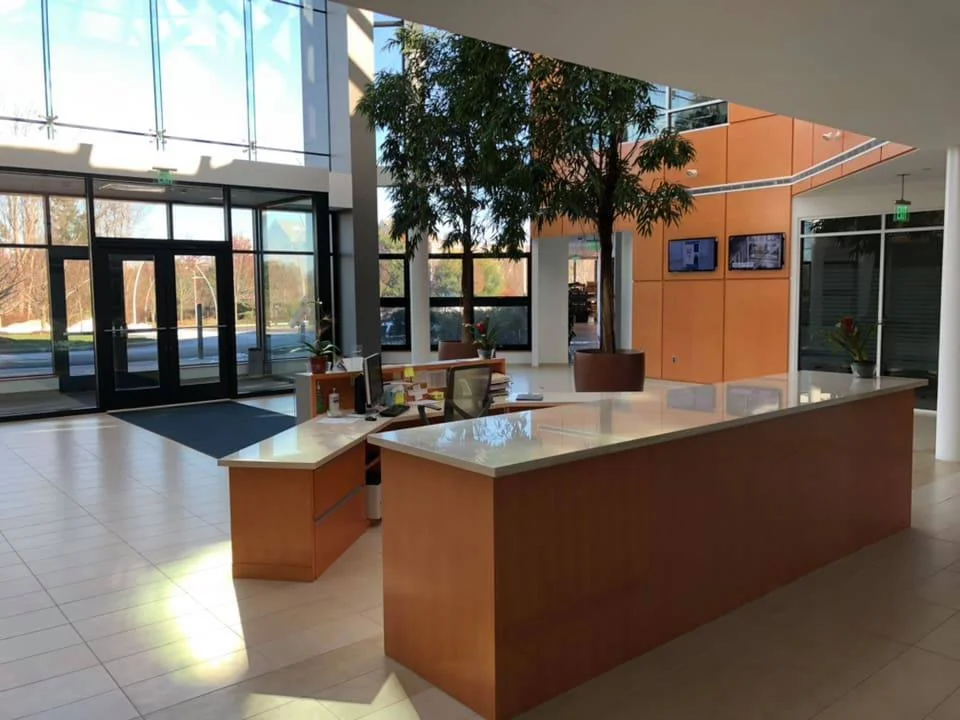 Clean commercial reception area with polished tile floors and a central front desk